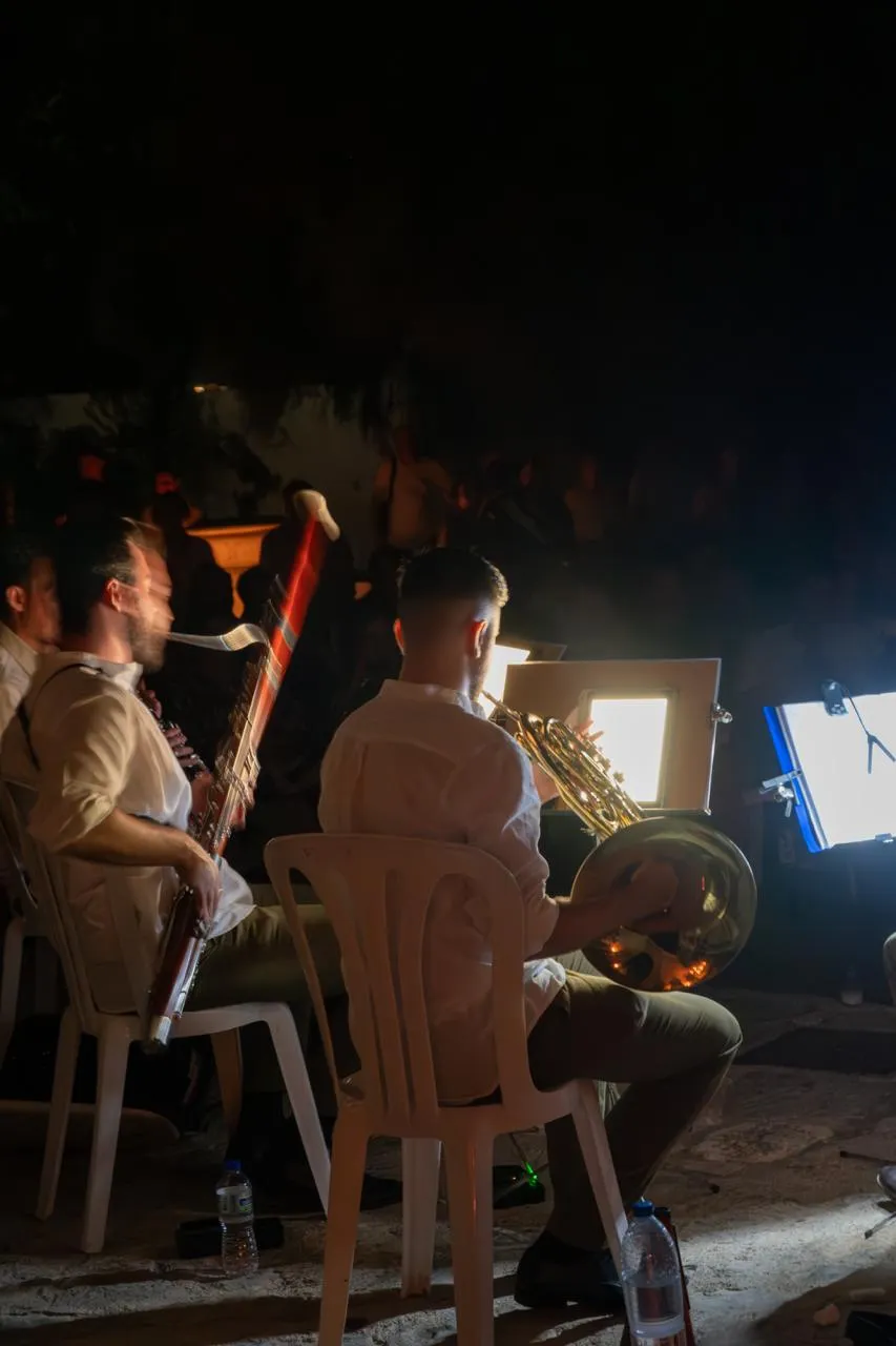 Músicos de Zayt Ensemble actuando de noche ante el público durante un concierto al aire libre