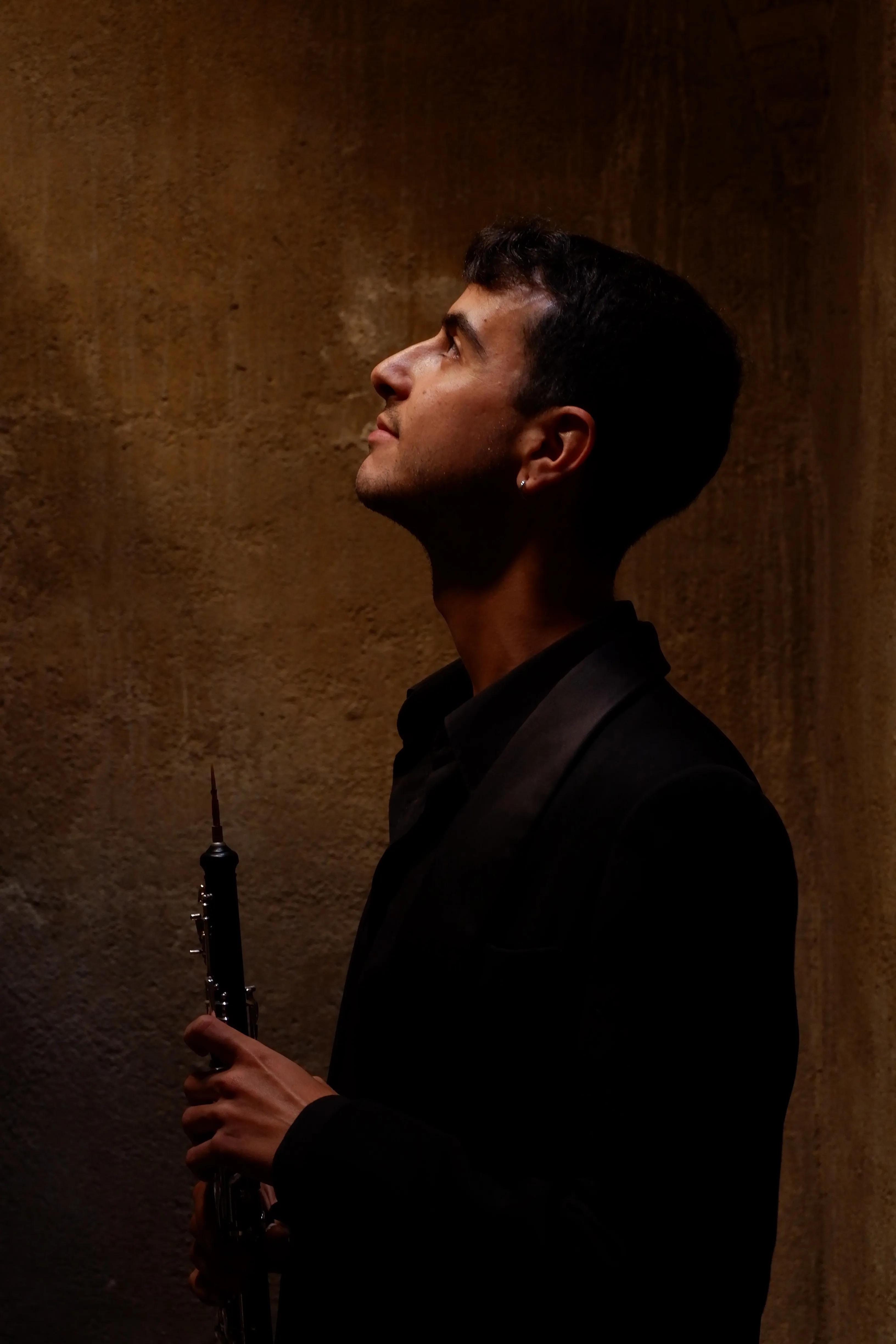 Retrato de un músico de Zayt Ensemble tocando el oboe con luz dramática